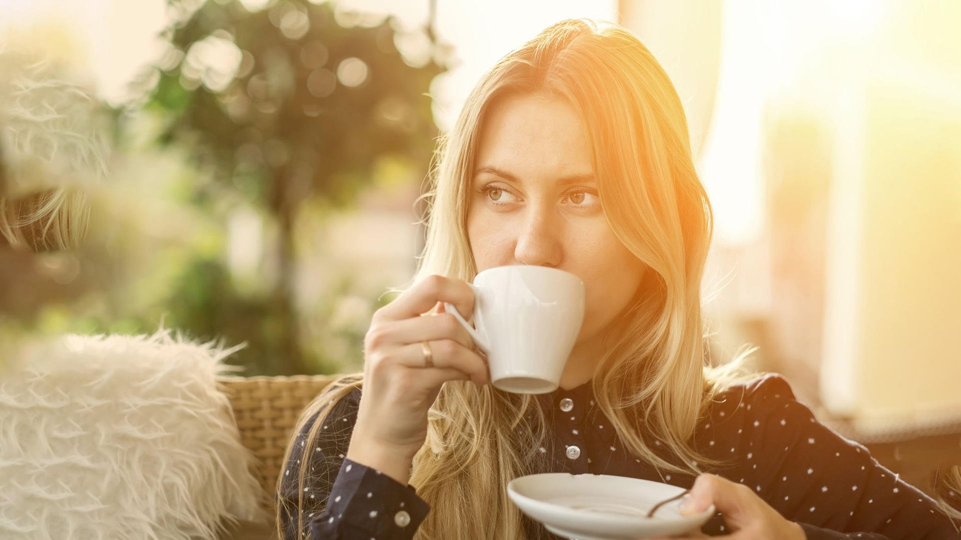 Счастливая девушка пьет кофе