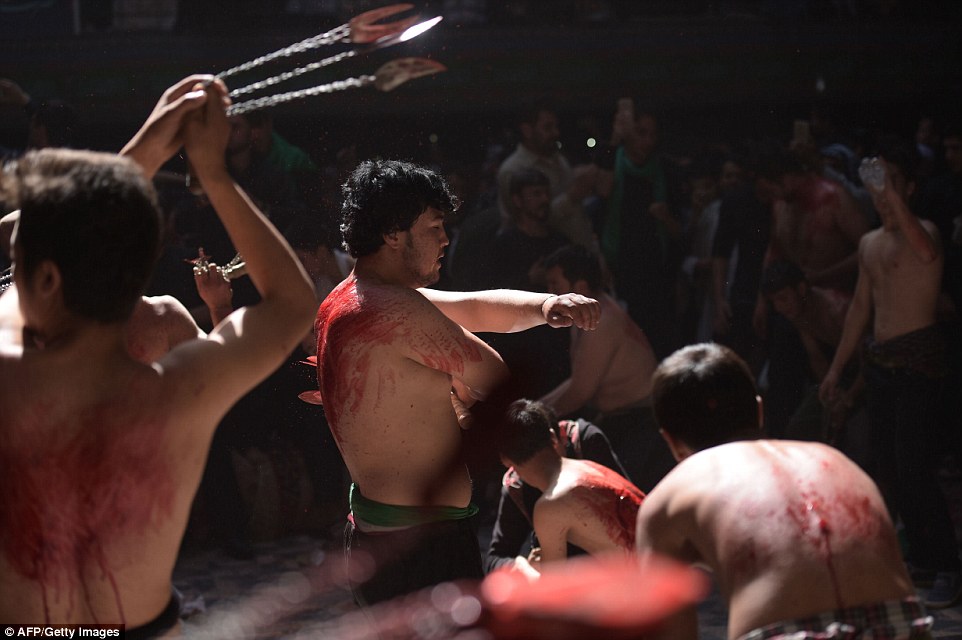 Ritual: Photographs of the event show young men, bleeding profusely from their backs, while afterwards they help each other wash away blood coming from their wounds