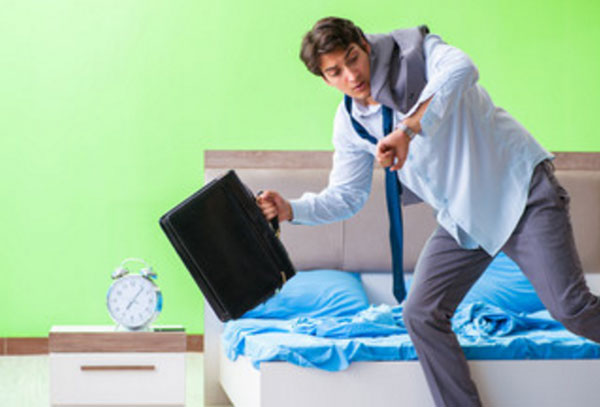 Мужчина впопыхах покидает свою комнату с чемоданом в руке